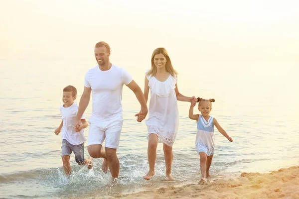 Szczęśliwa rodzina na plaży morskiej w kurorcie — Zdjęcie stockowe