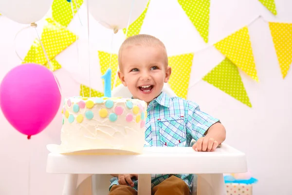 Bébé garçon mignon avec gâteau d'anniversaire sur fond lumineux — Photo