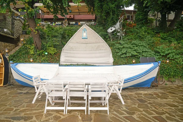 Tabela z krzesła i ławki w kształcie łodzi w dziedzińcu hotelu — Zdjęcie stockowe