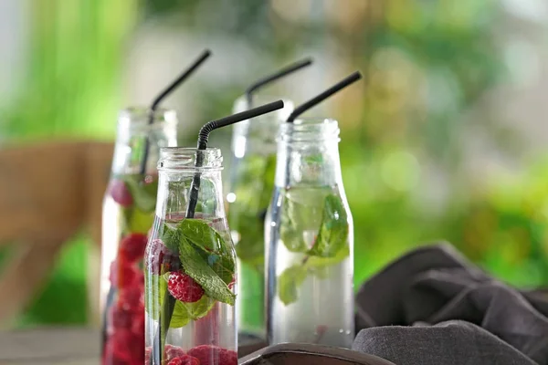 Flaschen mit Wasser und Beeren — Stockfoto