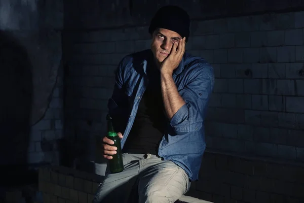 断念された建物にアルコールのボトルで座っている男 — ストック写真