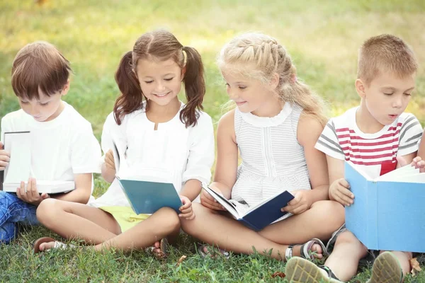 Lindos niños leyendo libros en el parque — Foto de Stock