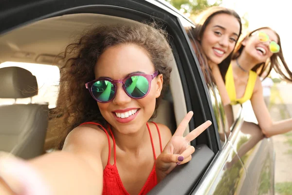 Jovens mulheres bonitas olhando para fora da janela do carro aberto — Fotografia de Stock