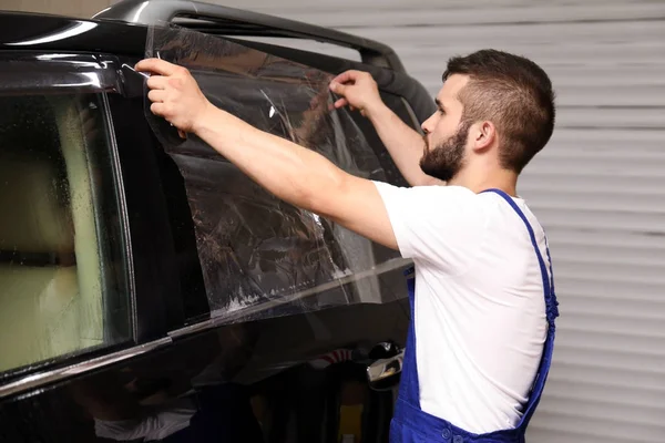 Arbeiter beschmiert Autoscheibe in Geschäft — Stockfoto