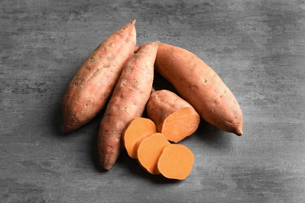 Słodkie ziemniaki na szarym tle — Zdjęcie stockowe
