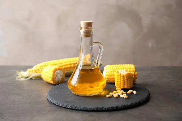 Glaskrug mit Maisöl und Maiskolben — Stockfoto
