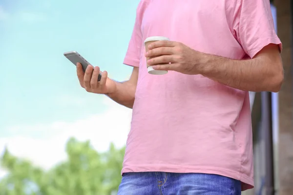 Adam akıllı telefon ve açık havada kahve — Stok fotoğraf