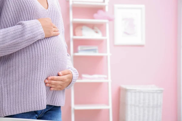 Mulher grávida em pé no quarto do bebê — Fotografia de Stock