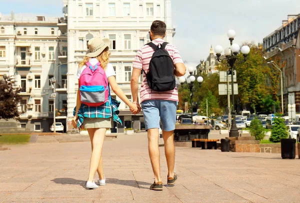 Felices turistas jóvenes caminando por la calle en la ciudad —  Fotos de Stock