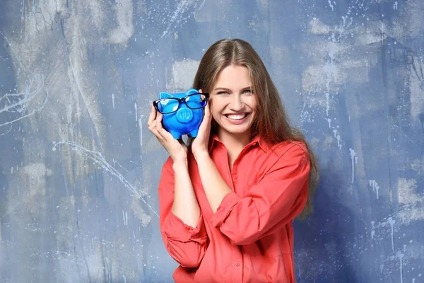 Jovem mulher com porquinho banco — Fotografia de Stock