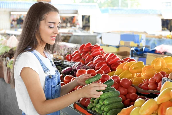 Junge Frau wählt Gemüse auf dem Markt — Stockfoto