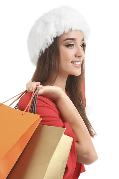 Mladá žena v Santa hat drží barevné tašky na bílém pozadí. Boxing day koncept — Stock fotografie