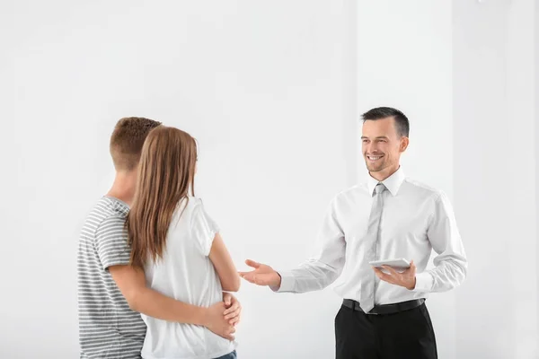 Happy family and estate agent with tablet in light new apartment — Stock Photo, Image