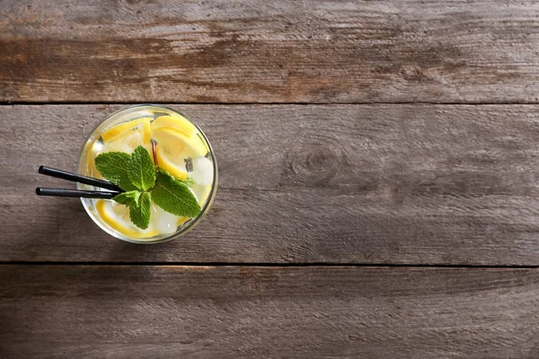 Bicchiere di cocktail con limone e menta su fondo di legno — Foto Stock