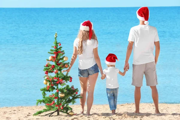 Família feliz e árvore de Natal na praia — Fotografia de Stock