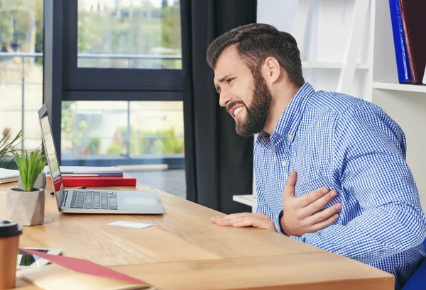 Fiatal férfi szenved, mellkasi fájdalom, iroda — Stock Fotó