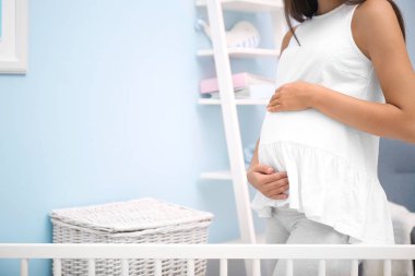 Bebeğin odasında duran hamile kadın