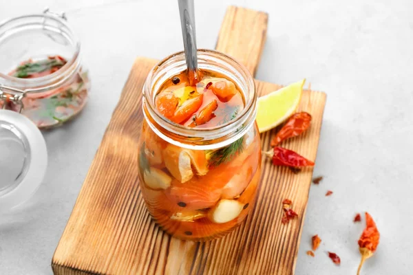 Jar with delicious marinated salmon on table — Stock Photo, Image