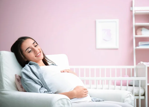 Pregnant woman sitting in baby's room — Stock Photo, Image