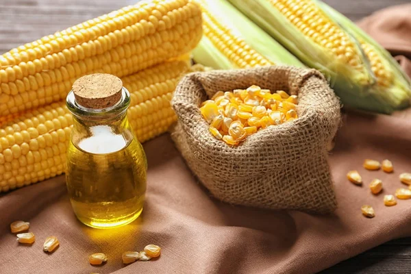 Glass jar with corn oil and dried kernels — Stock Photo, Image