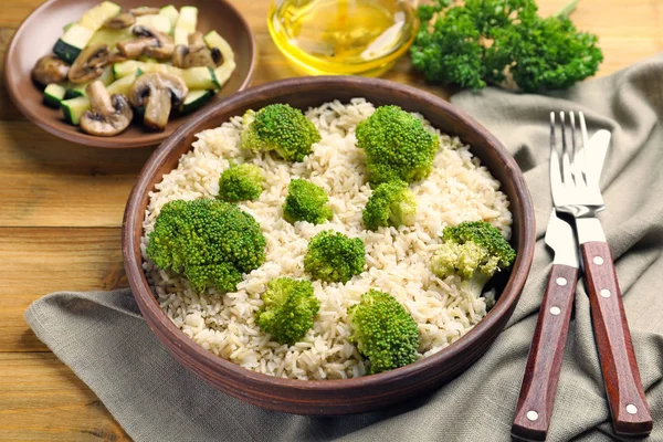 Skål med råris och broccoli på bord — Stockfoto