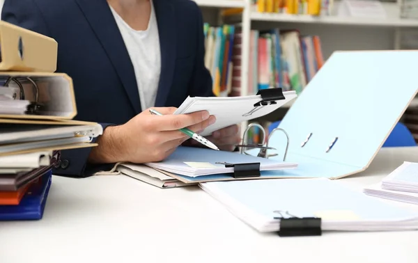 Man working with documents at table in archive