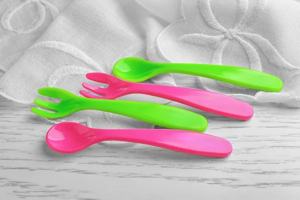 Utensili colorati in plastica per mangiare per il bambino sul tavolo — Foto Stock