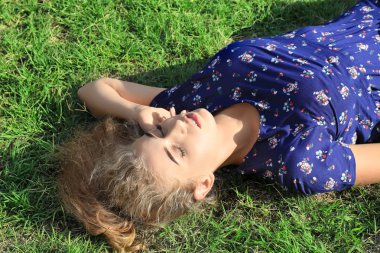 Güzel genç kadın açık havada yeşil çimenlerin üzerinde rahatlatıcı