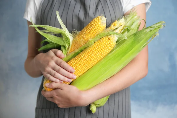 Woman holding fresh corn cobs on grunge background — Stock Photo, Image