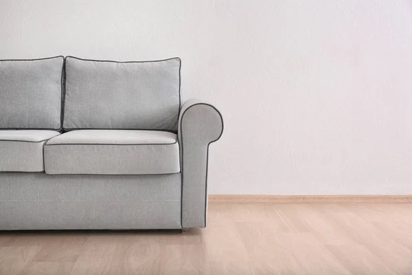 Gemütliches Sofa auf hellem Wandhintergrund — Stockfoto