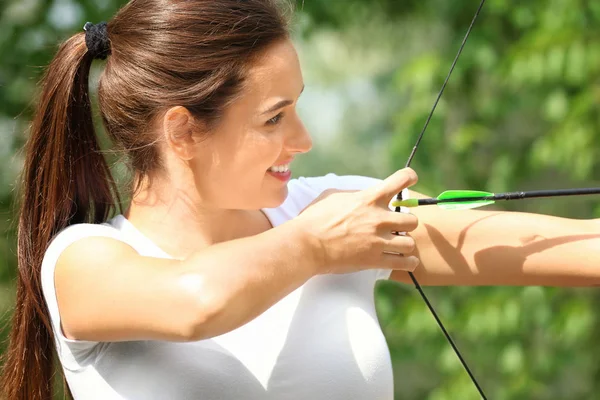 Mujer joven practicando tiro con arco — Foto de Stock
