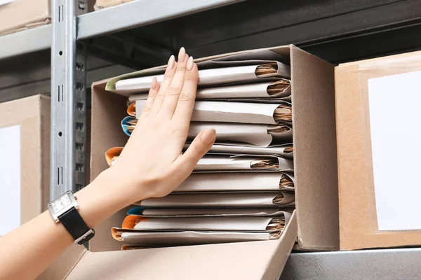 Vrouw op zoek naar documenten in archief — Stockfoto