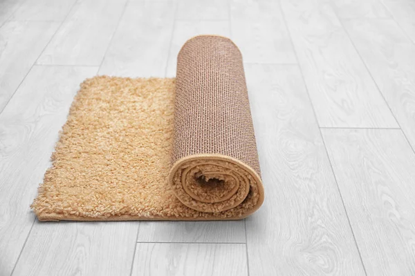 Kleur tapijt gerold op houten vloer — Stockfoto