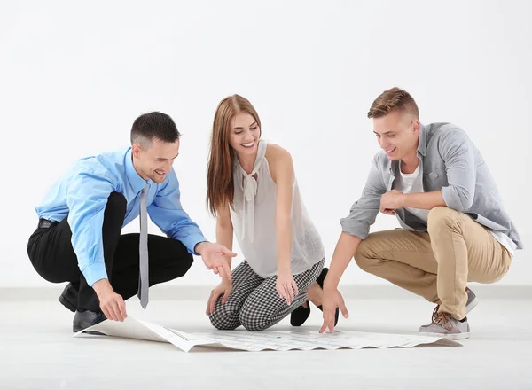 Makelaar met project en gelukkige paar in nieuw appartement — Stockfoto