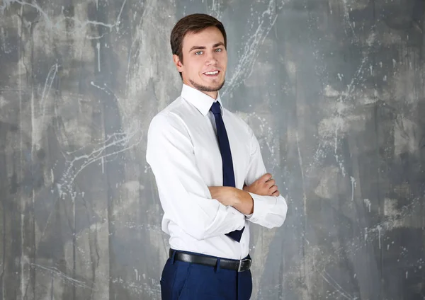 Jovem atraente em desgaste formal em fundo cinza — Fotografia de Stock