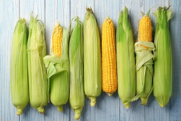 Fresh corn cobs on wooden table — Stock Photo, Image