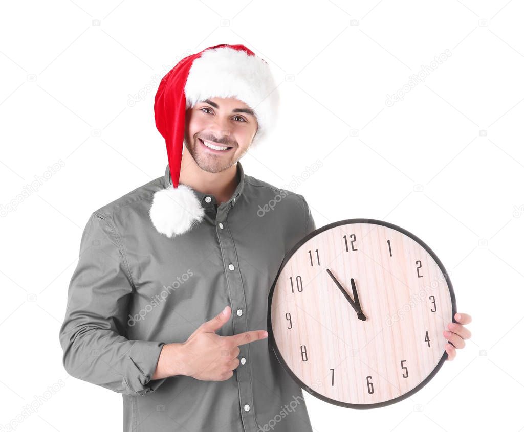 Young man in Santa hat with clock on white background. Christmas countdown concept