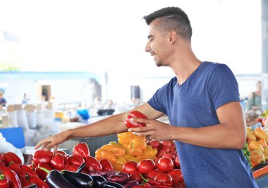 Genç adam Pazar sebze seçme