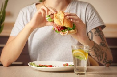 Lezzetli sosisli sandviç kapalı tutan kadın