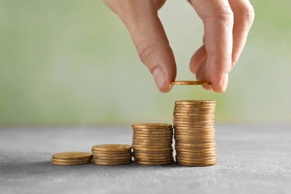 Woman stacking coins on blurred background, closeup — Stock Photo, Image