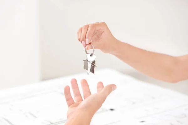 Agente inmobiliario dando llave de nuevo apartamento al hombre en la oficina — Foto de Stock