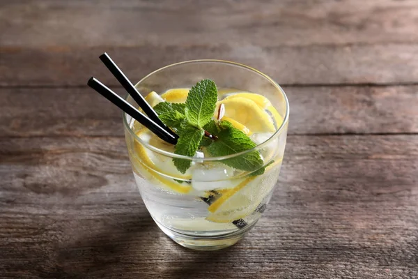 Sklenice koktejlu s citrónem a mátou na dřevěném pozadí — Stock fotografie