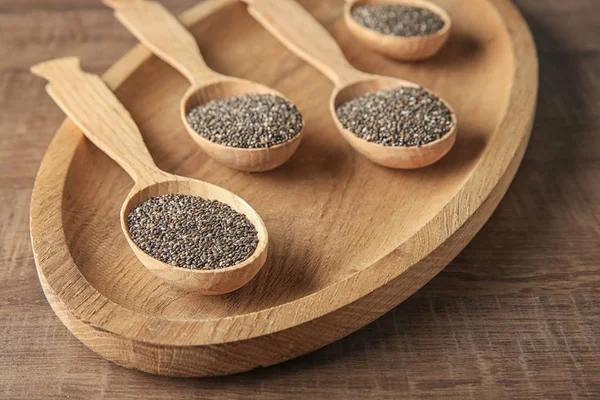 Cucharas con semillas de chía en plato de madera — Foto de Stock