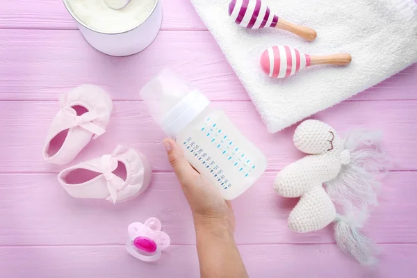 Bebek süt formülü besleme şişe ahşap arka plan üzerinde tutan kadın — Stok fotoğraf