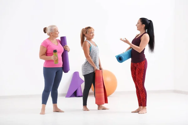 Women with yoga mats indoors — Stock Photo, Image