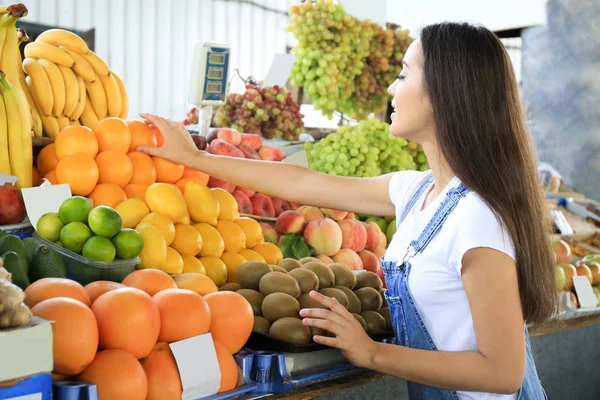 Junge Frau wählt Obst auf dem Markt — Stockfoto