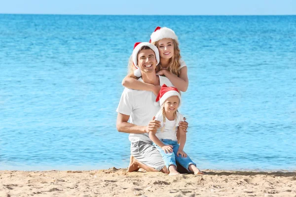 Młoda para z dziewczyna na plaży. Boże Narodzenie celebracja koncepcja — Zdjęcie stockowe