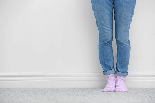 Mujer de pie en la alfombra cerca de la pared blanca — Foto de Stock