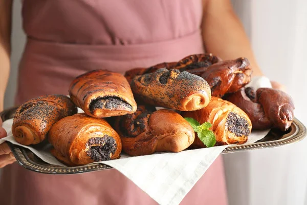 Mulher segurando bandeja de doces saborosos com sementes de papoula, close-up — Fotografia de Stock