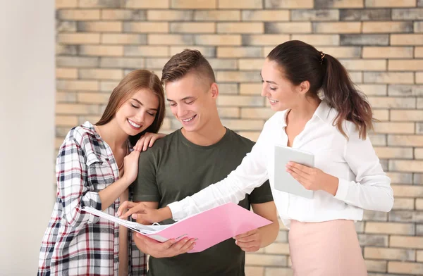 Agen Estate dengan tablet yang menunjukkan pasangan bahagia dokumen di flat — Stok Foto